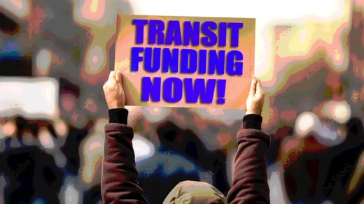 Protester holding up sign that reads "Transit funding now!"